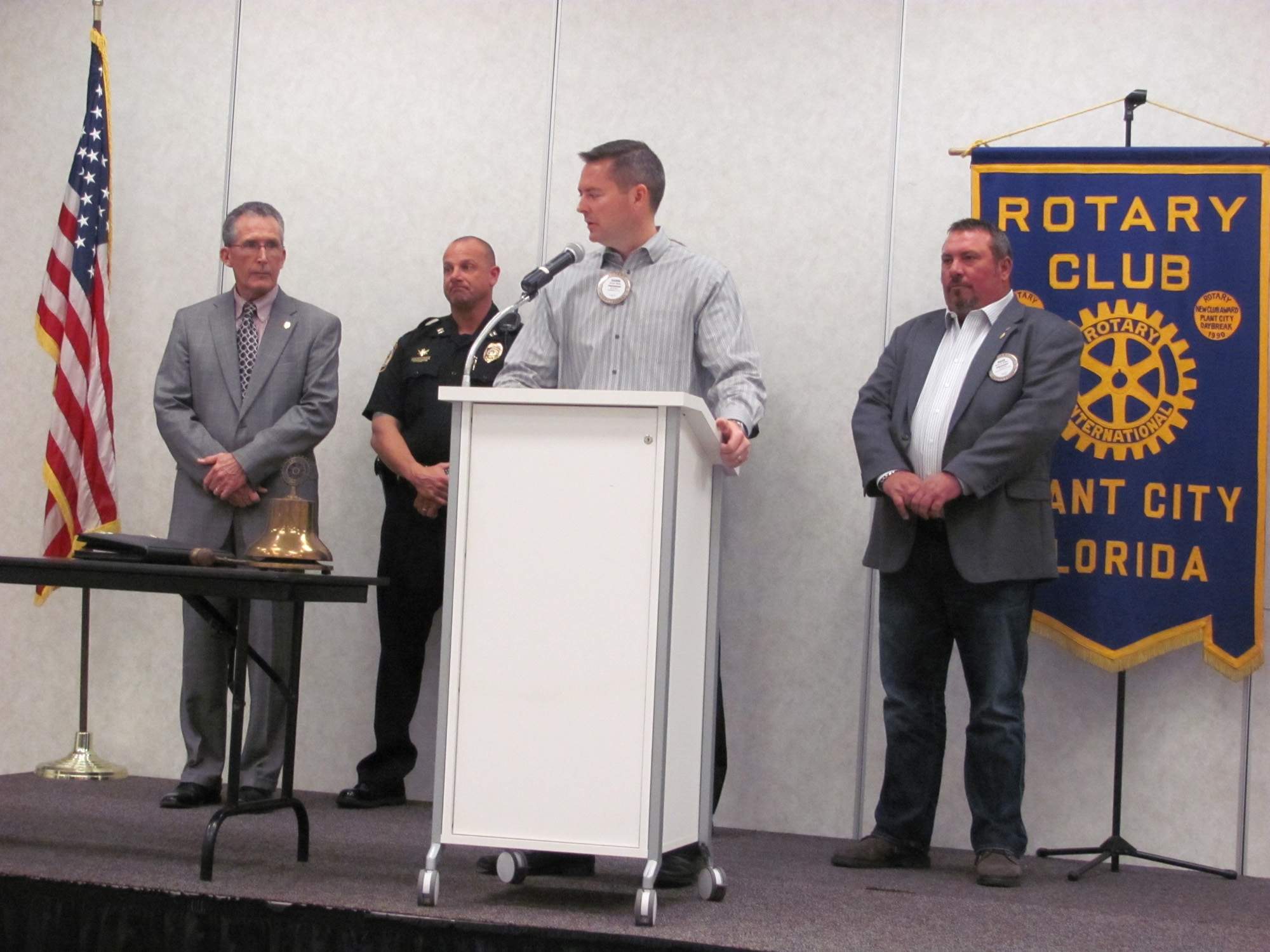 Former Rotary Club President Aaron Davis takes a turn at the microphone as the club turns over the last of the 50 automated external defibrillators that the Rotary donated to the police department. Police Chief Ed Duncan, left, Capt. Dave Millich and Rotary Club President Brian Griffin look on. for DAVE NICHOLSON