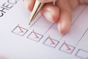 Cropped image of businesswoman writing on checklist