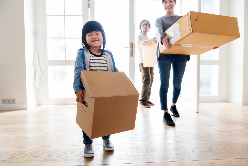 Child Moving Boxes into New Home