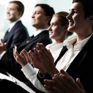 Tilt up of roup of business people applauding to a successful speaker